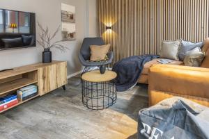 a living room with a couch and a chair at Pier17 Appartement 2 in Borkum