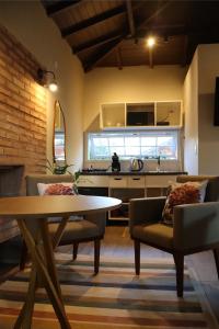 a living room with a table and chairs and a kitchen at Pousada Villa Luna in Penedo