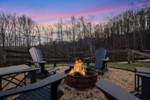 two chairs and a fire pit in a yard with a sunset at Blue's Barn in Nellysford