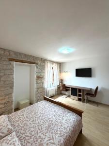 a bedroom with a bed and a flat screen tv at Tea Rooms in Bale