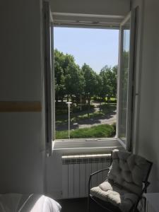 a chair sitting in front of a window with a view at Acionna Résidence Studio 30 M² in Bourbonne-les-Bains