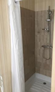 a shower with a white shower curtain in a bathroom at Acionna Résidence Studio 30 M² in Bourbonne-les-Bains