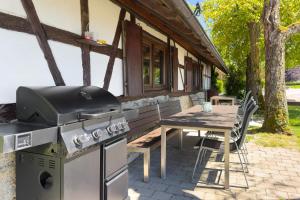 a outdoor patio with a grill and a table at Gästehaus Heinemann - Dg4 in Langenargen