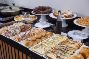a buffet filled with different types of bread and pastries at Hotel Descalvado in Descalvado