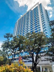 a large white building with trees in front of it at Loop Towers by Vista Residences in Pontud