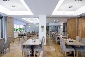 a dining room with tables and chairs at Hotel TISA in Băile Olăneşti