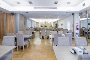 a restaurant with tables and chairs in a room at Hotel TISA in Băile Olăneşti +96 photos