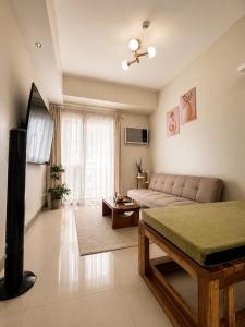 a living room with a couch and a table in a room at Oasis 8 in Bacolod