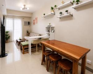 a living room with a table and chairs and a couch at Oasis 8 in Bacolod