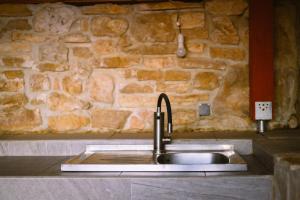 a sink in a kitchen with a stone wall at Stars in Gornji Karin +217 photos