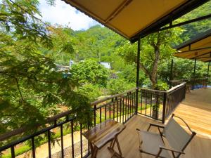 a deck with two chairs and a bench on it at Suối Mộc Ecostay - Mộc Châu in Mộc Châu