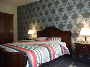 a bedroom with a bed and two end tables with lamps at Désir D'un Soir in Lessines