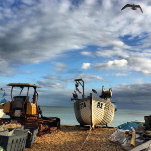 two boats on a beach with a cloudy sky at Harbour Beach Apartment in Pevensey