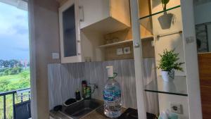 a kitchen with a sink and a bottle of water on a counter at Student Castle Apartement by Dev's Room in Seturan +14 photos