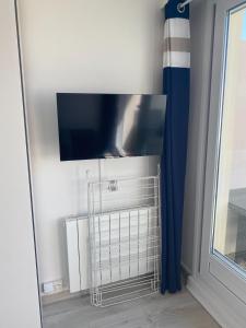a flat screen tv on a wall next to a window at Le Sunny Hardelot in Neufchâtel-Hardelot