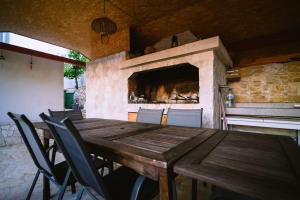 a wooden table and chairs in front of a stone fireplace at Stars in Gornji Karin