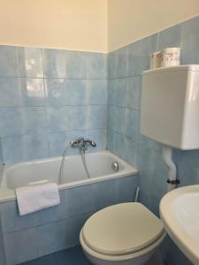 a blue bathroom with a toilet and a bath tub at Albergo Bandoni in Rapallo +71 photos