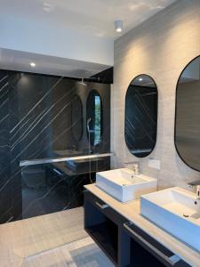 a bathroom with two sinks and two mirrors at Navis Suites & Spa in Mandre