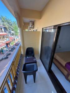 a room with a balcony with a chair and a window at Prakash Holiday Inn in Arambol