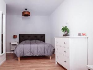 a bedroom with a bed and a white dresser at 1 Le Cocon Mosaïque Centre-ville in Ernée