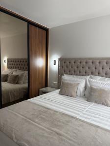 a bedroom with two beds and a large mirror at Navis Suites & Spa in Mandre