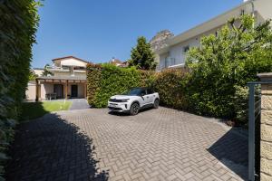 a white car parked in front of a house at Meteora boutique villa E in Kalabaka