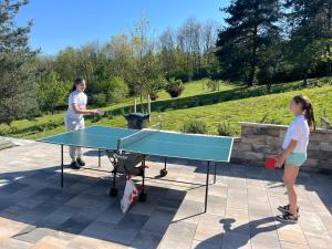 a woman and a girl playing a game of ping pong at Šumska Duša in Banja Luka