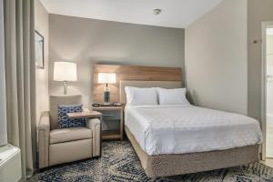 a hotel room with a bed and a chair at Candlewood Suites Longview by IHG in Longview