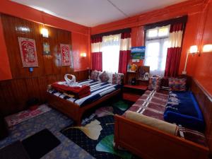 a bedroom with two beds and a couch in it at Homestay Blue Horizon in Darjeeling