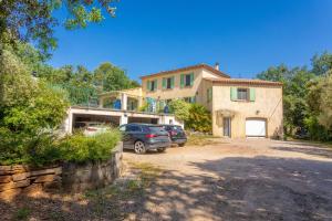 ein Haus mit zwei in der Einfahrt geparkten Autos in der Unterkunft Villa Same in Saint-Maximin-la-Sainte-Baume