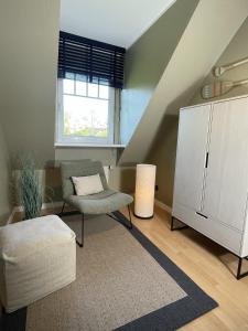 a living room with a chair and a refrigerator at 4Strandzeiten - Ferienhaus Luv in Timmendorfer Strand +27 photos