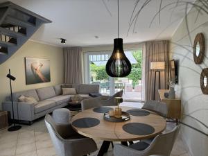a living room with a table and a couch at 4Strandzeiten - Ferienhaus Luv in Timmendorfer Strand