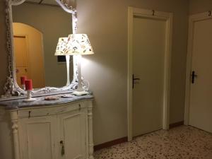 un bagno con specchio e lampada su un comò di Albergo Sangrilà a Lanzo Torinese