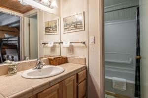 a bathroom with a sink and a mirror at Chalet 15 by Mammoth Mountain Chalets in Mammoth Lakes +4 photos