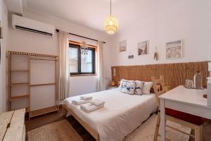 a bedroom with a bed with towels on it at Guest House Da Mata3 in Póvoa de Varzim