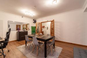 a dining room with a black table and chairs at Guest House Da Mata3 in Póvoa de Varzim