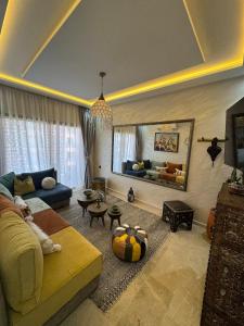 a living room with a yellow couch and a mirror at Prime location Moroccan-Style Luxury Apartment with Parking near Carré Eden Shopping Center in Marrakesh