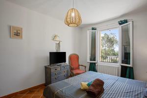 ein Schlafzimmer mit einem Bett, einem Stuhl und einem Fenster in der Unterkunft Villa Same in Saint-Maximin-la-Sainte-Baume