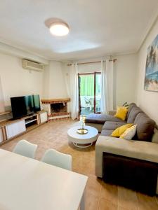 a living room with a couch and a tv at SiCasa Punta Prima in Punta Prima