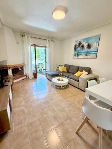 a living room with a couch and a table at SiCasa Punta Prima in Punta Prima