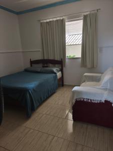 a bedroom with two beds and a window at Casa ampla in Muriaé