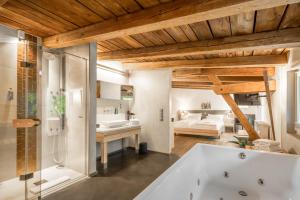 a bathroom with a bath tub and a bedroom at Klostermühle in Groß Meckelsen