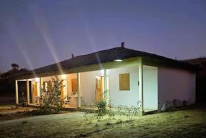 a small white house with the lights on at Vacaciones Timonier in Ndangane