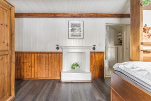 a bedroom with a bed and a fireplace at Lyckebo in Gunnebo