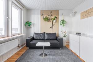a living room with a black couch and a table at Lyckebo in Gunnebo