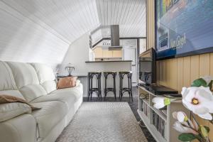 a living room with a white couch and a tv at Lyckebo in Gunnebo