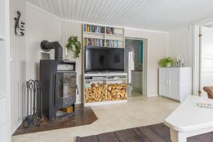 a living room with a fireplace and a tv at Lyckebo in Gunnebo +16 photos