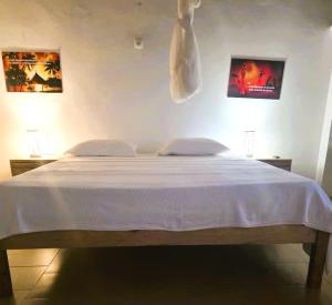 a bedroom with a large bed with white sheets at Vacaciones Timonier in Ndangane