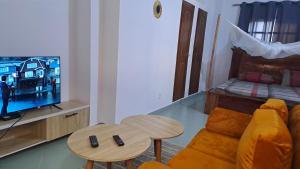 a living room with a couch and a tv and a bed at DAVADI loc in Cotonou +5 photos