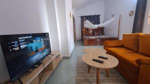 a living room with a couch and a tv and a table at DAVADI loc in Cotonou